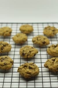 baked chocolate chip cookies on black cooling rack on white surface