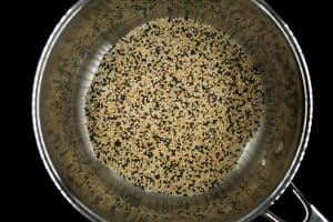 Bibimbap - tri-colored sesame seeds in a silver pot in black surface