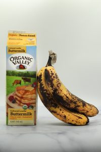 overripe bananas and organic valley buttermilk on a white surface