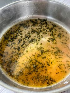 melted brown butter and sauvignon blanc white wine in saucepan with minced fresh thyme and sage