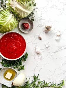 how to make stuffed cabbage rolls - above shot of all the ingredients on a white marble surface