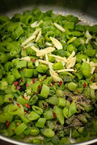 Sugar snap peas, thinly sliced garlic, scallions, salt, pepper, and red pepper flakes in a sauté pan