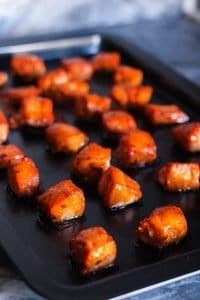 Salmon Rice Bowls with Avocado Salsa and Mango Sauce: cooked honey chipotle salmon bites on a sheet baking pan