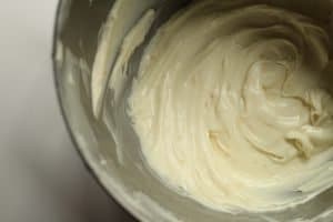Orange Cream Cheese Frosting in a silver kitchenaid bowl.