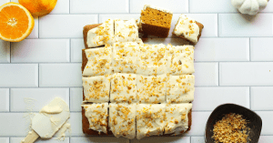 Sliced pumpkin cake squares with orange cream cheese frosting.