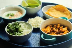 Chorizo Breakfast Tacos with Cilantro Lime Crema - ingredients set out in separate bowls on a blue platter.