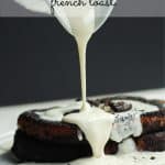 Cream cheese glaze being poured over cookies and cream French toast on a white plate.