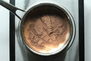 2 ingredient protein hot chocolate ingredients (vital proteins collagen and milk) in a saucepan.