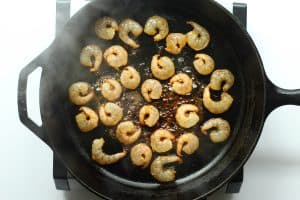 Shrimp cooking in a cast iron pan.