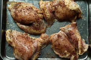 Seasoned chicken thighs on a tray for southwest chicken bowls.