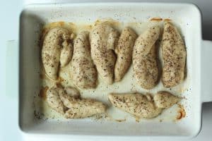 Protein pasta salad with chicken - cooked seasoned chicken in a white baking dish.