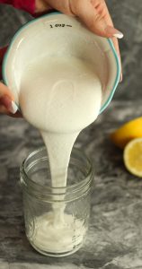 Lamb kofta wraps creamy feta yogurt sauce being poured into a mason jar.