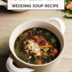 Italian wedding soup recipe with golden seared meatballs in a beige bowl with handles.