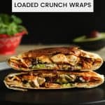 Baked chicken loaded crunch wrap cut in half and stacked on a black plate.
