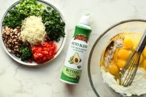 Veggie egg bites chopped vegetables on a round plate with shredded cheese, cooking spray, and a bowl with eggs and yogurt.