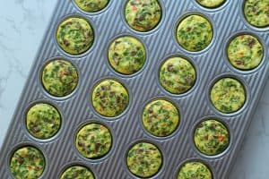 Cooked veggie egg bites in a silver mini muffin pan.