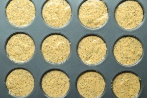 Orange poppyseed muffins batter poured into 12 muffin tins.