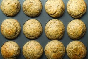 12 baked orange poppyseed muffins in the muffin pan.