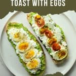 Two pieces of avocado Toast with Cottage Cheese topped with things like eggs, tomatoes, sprouts, etc. on a white plate.