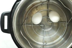 Two eggs in an instant pot with the egg basket.