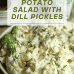 Potato salad with dill pickles and a sprig of dill in a speckled bowl.