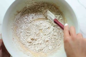 Carrot cake loaf batter dry ingredients being folded into the wet ingredients with a rubber spatula.